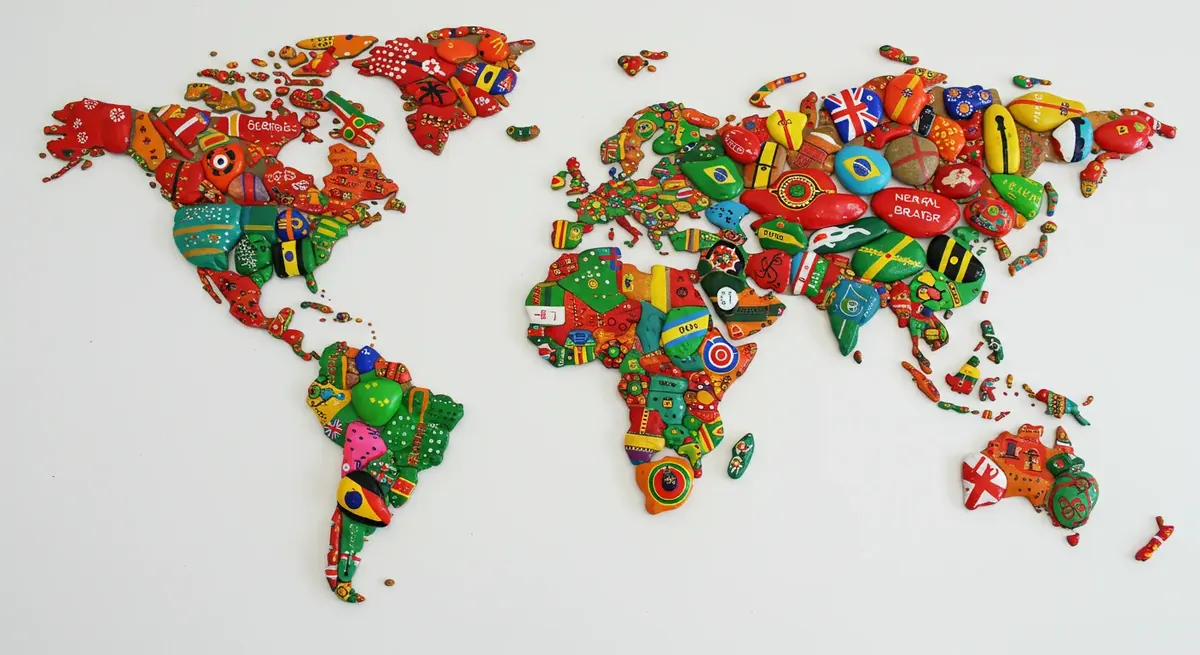 World map with painted rocks placed on different continents celebrating International Rock Painting Day