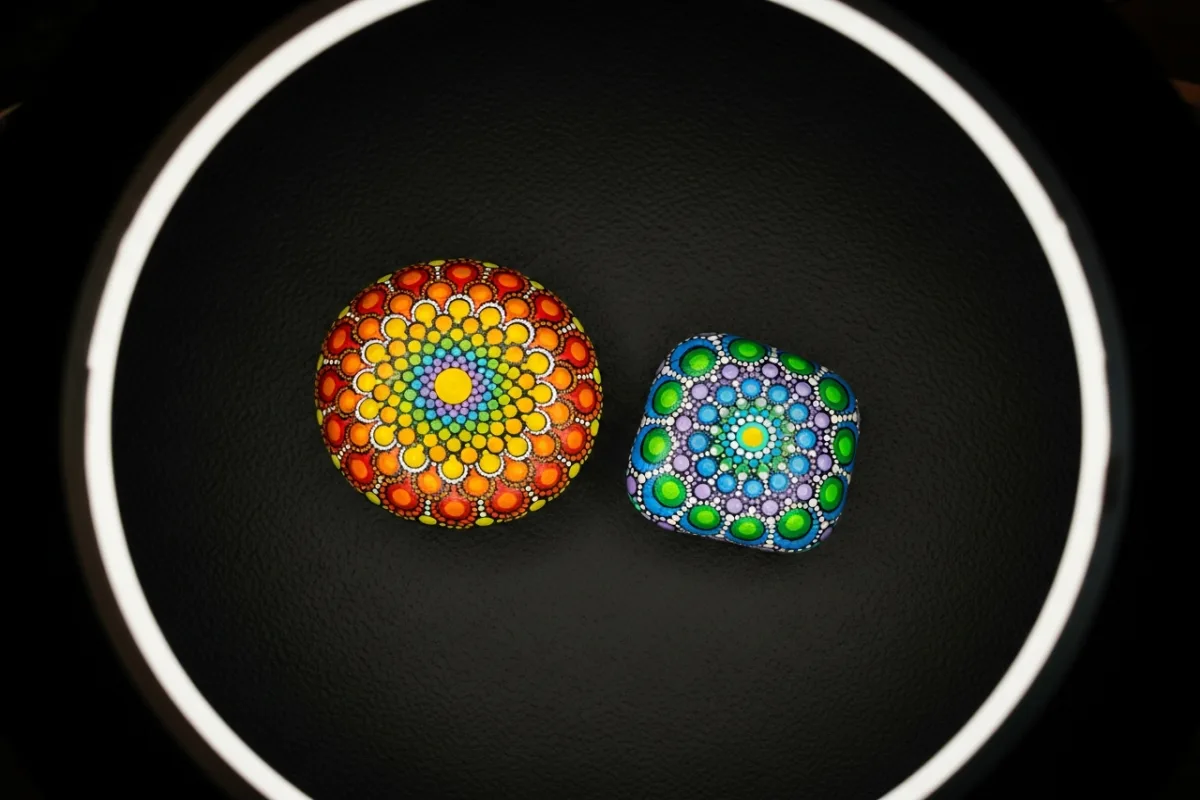 Overhead two painted rocks on dark background with dramatic lighting