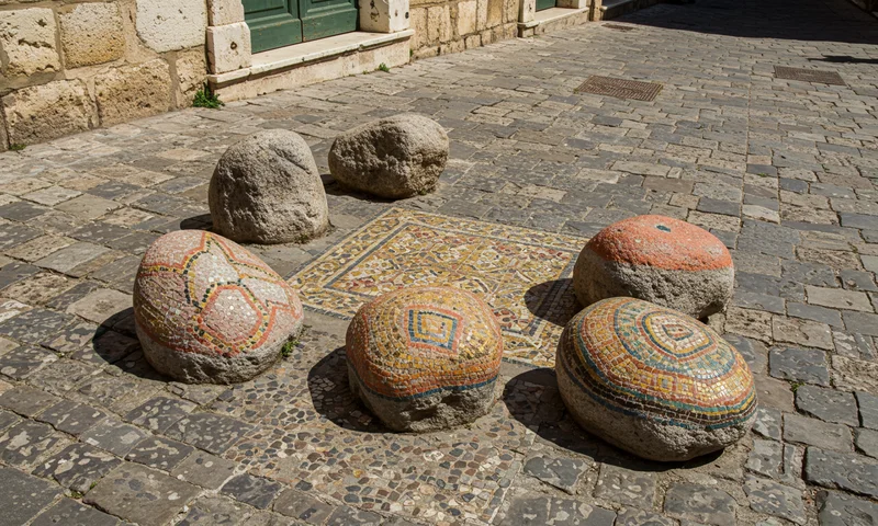 Sassi dipinti with Mediterranean mosaic patterns on a stone wall in Villa Borghese, Rome, Italy
